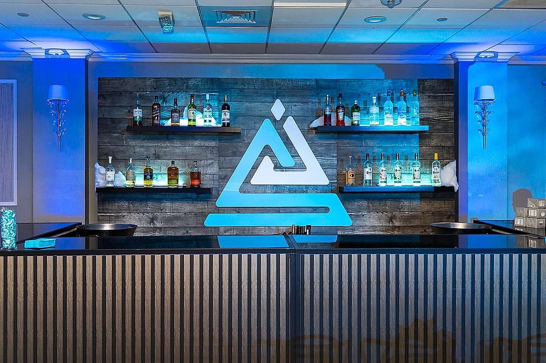 Bar with backlit shelves and an illuminated geometric logo