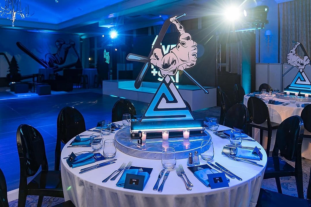 Round table set beneath an illuminated skier centerpiece