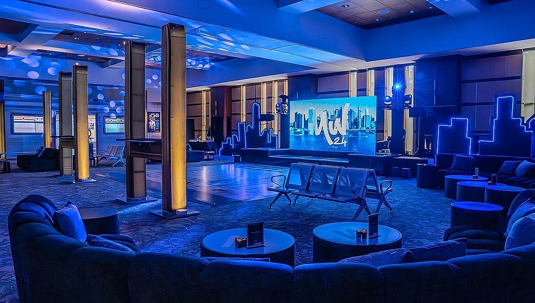 Lounge with blue seating and city-skyline accents beneath warm columns