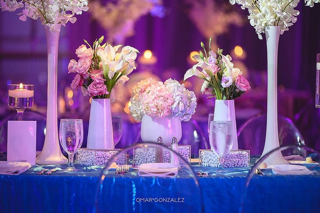 White vases with pink and white flowers and floating candles