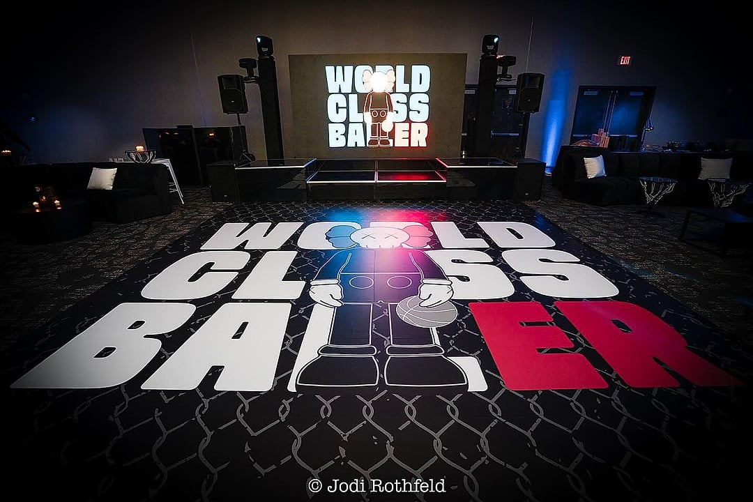 Custom dance floor graphic beneath a lit stage