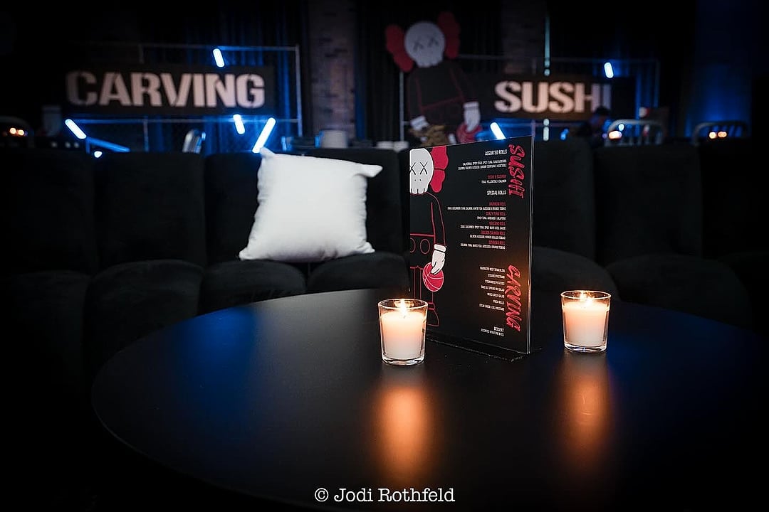 Lounge table with candles and a menu card before food stations