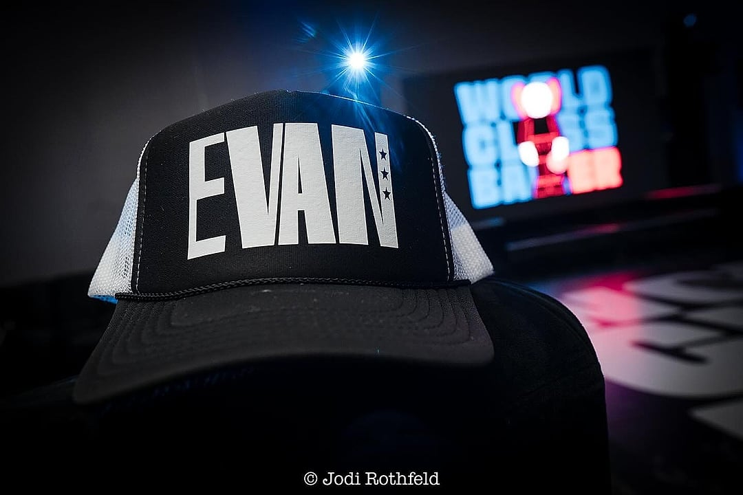 Custom trucker hat on a chair with the party screen behind