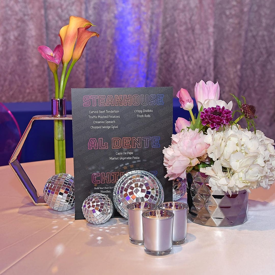 Calla lilies, roses and disco-ball accents beside a menu sign