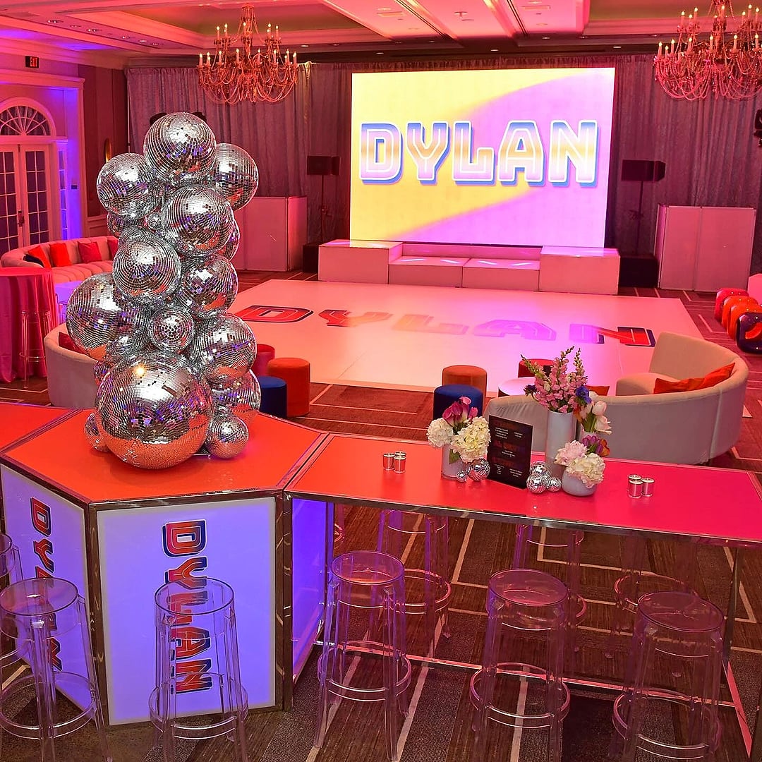 Disco-ball centerpiece on a monogrammed table before a name screen