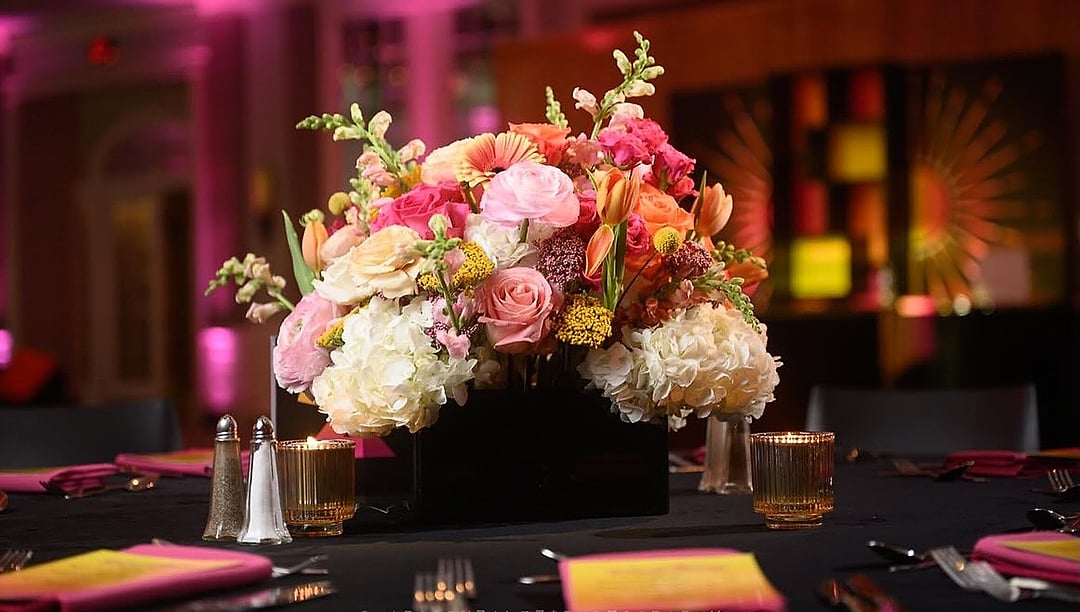 Pink, peach and white floral centerpiece in warm light