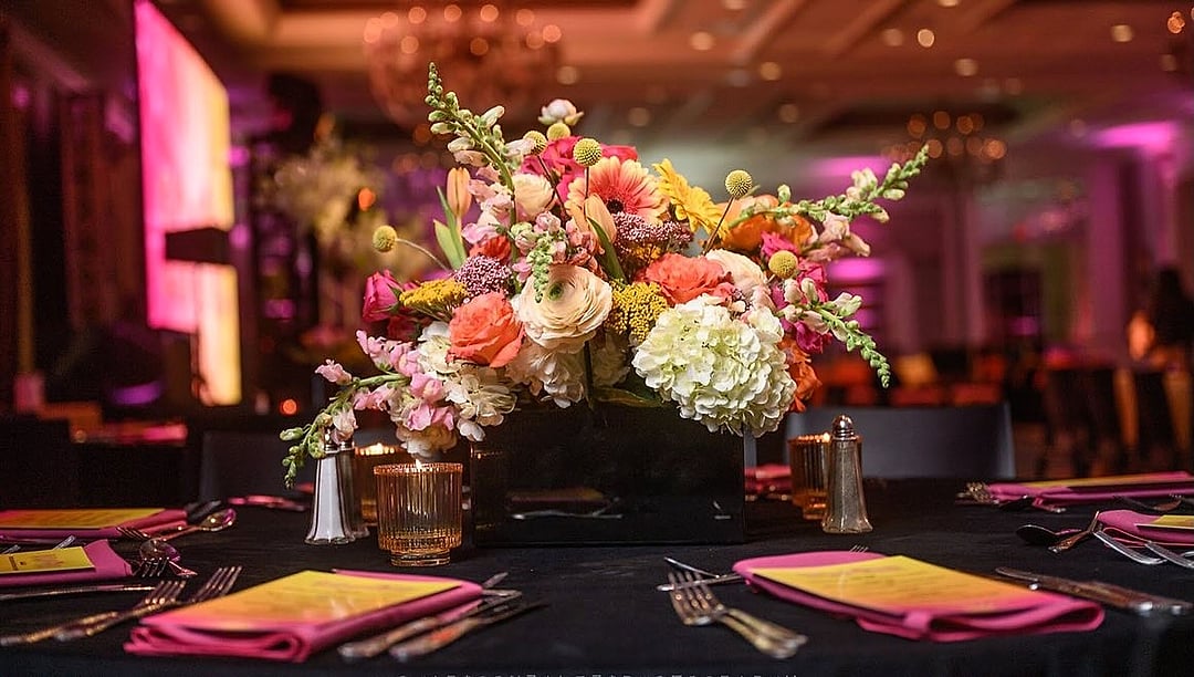 Low floral arrangement on a black table glowing in sunset tones