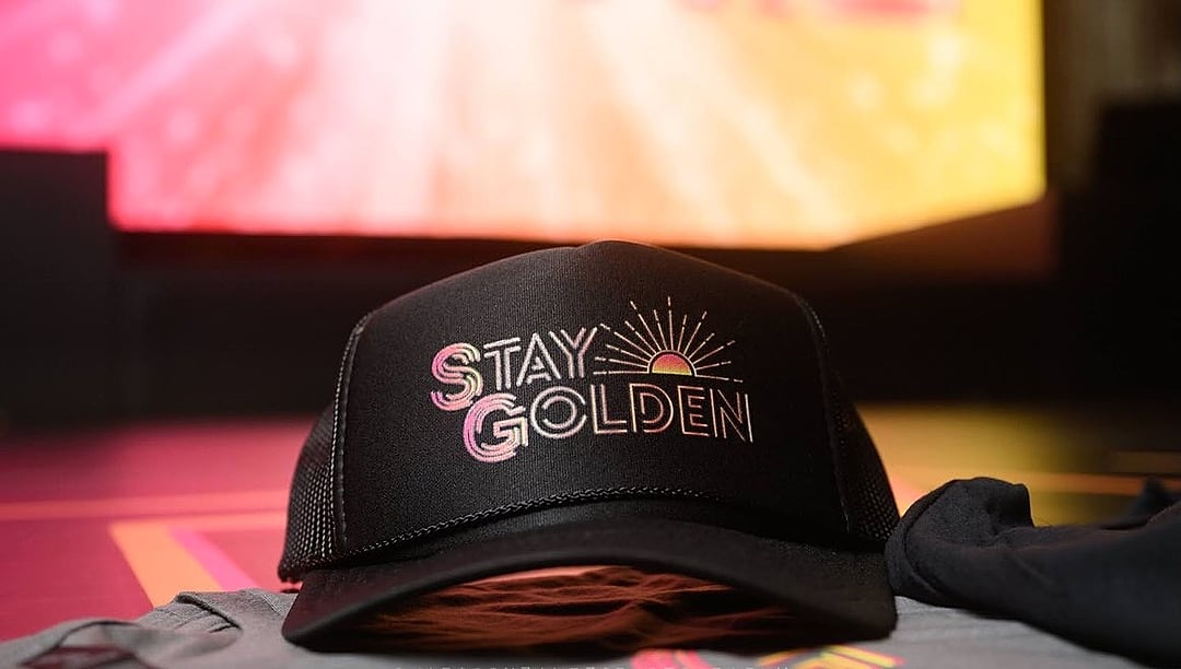 Black trucker hat with a golden sunburst design