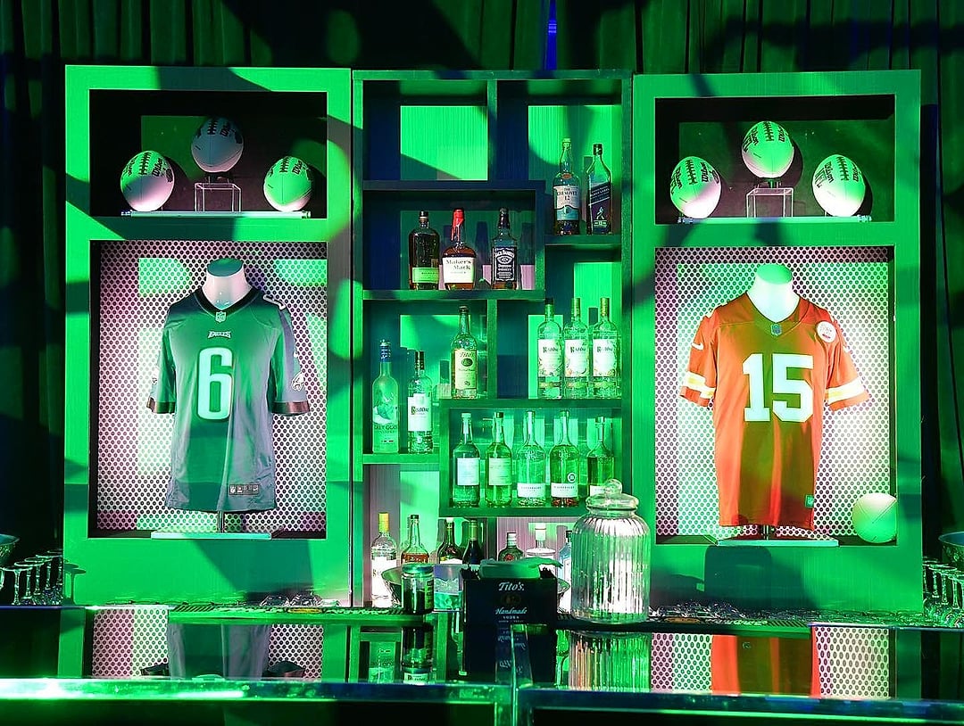Bar displaying framed football jerseys in green light