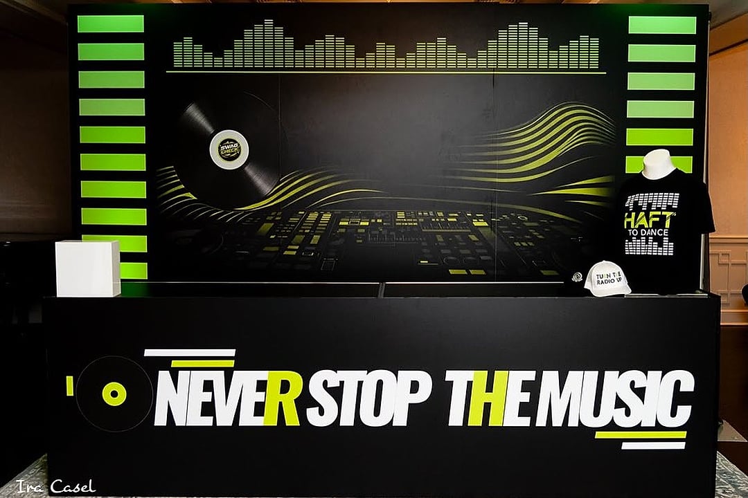 DJ booth with a music-themed backdrop and lettering