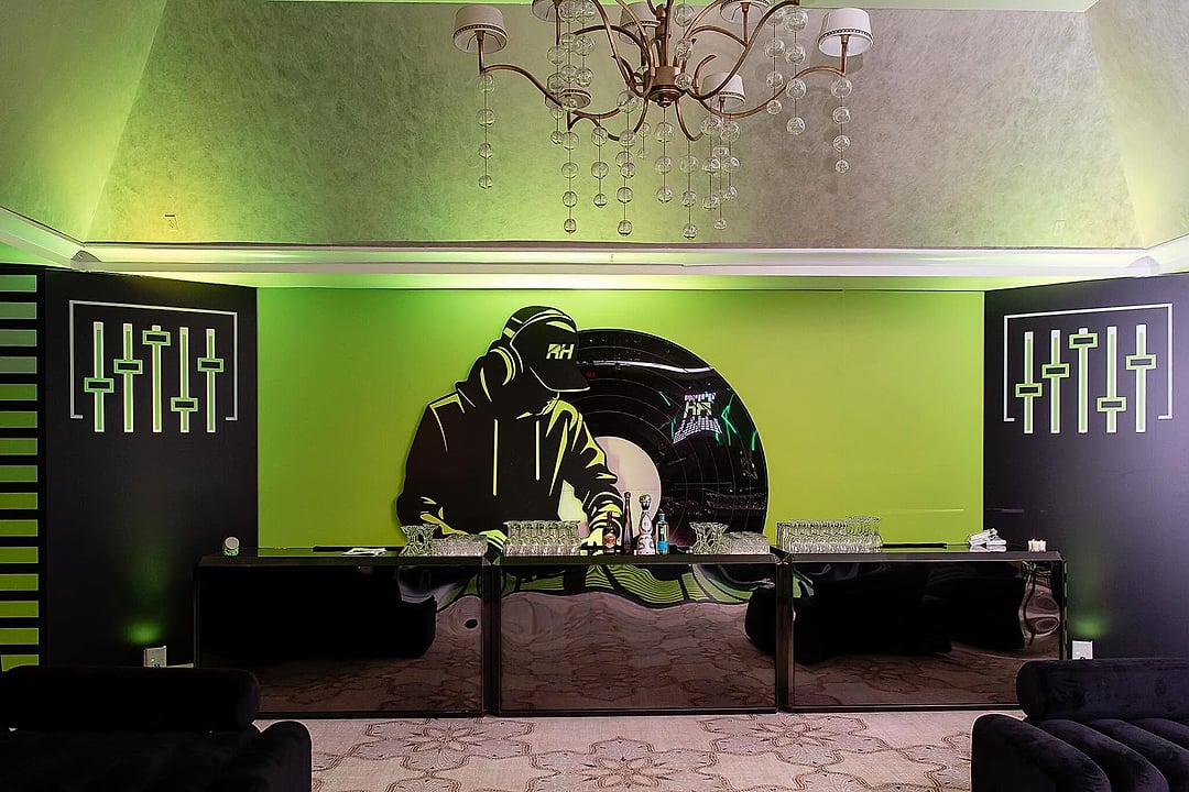 Lime-green music-themed backdrop behind a long table